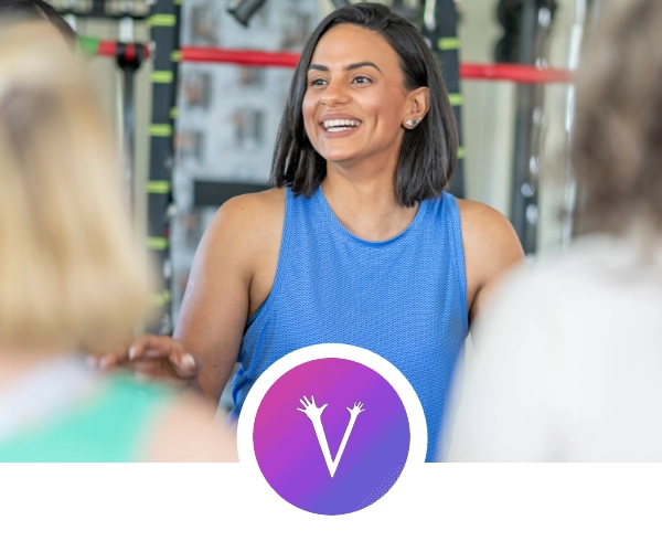 Fitness instructor qualified to teach exercise for older adults leading a class of two older women,