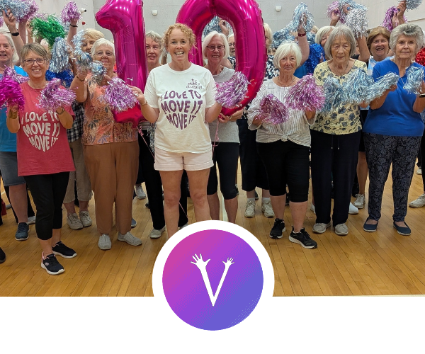 Exercise instructor for older adults leading a Move it or Lose it class in a community hall
