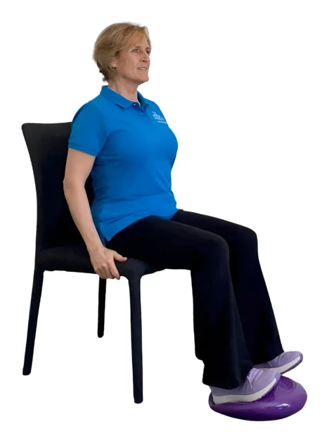 Move it or Lose it instructor demonstrating the ankle flexibility wobble cushion exercise on a chair