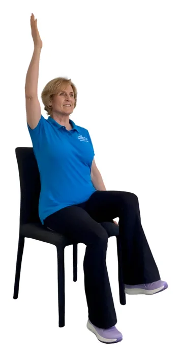 Move it or Lose it instructor demonstrating the arm and leg lifts wobble cushion exercise on a chair